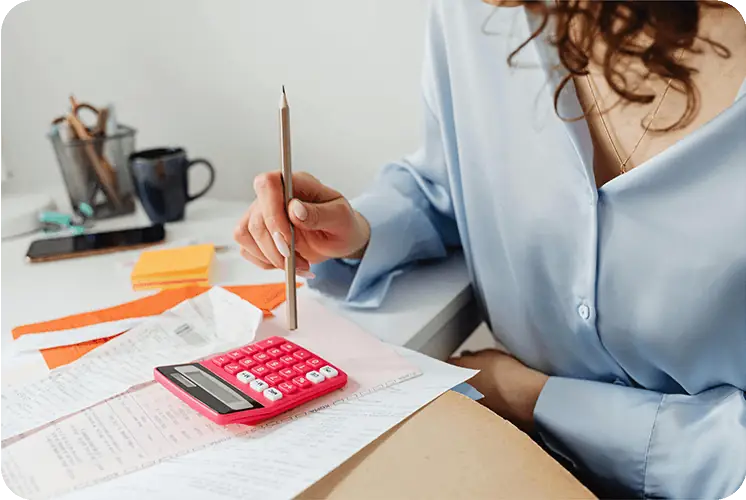 A woman working out costs with a calculator